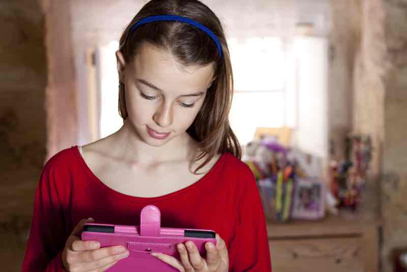 Pretty teenager reading from her eook tablet