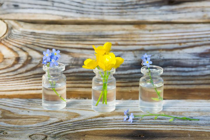 buttercups and forget-me-nots in small glass jars